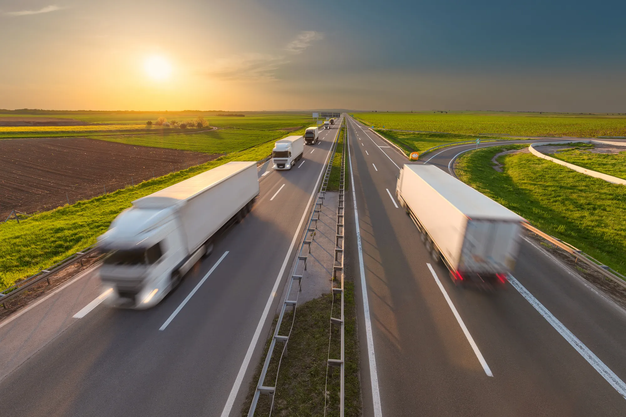 two lanes of highway with trucks speeding down them