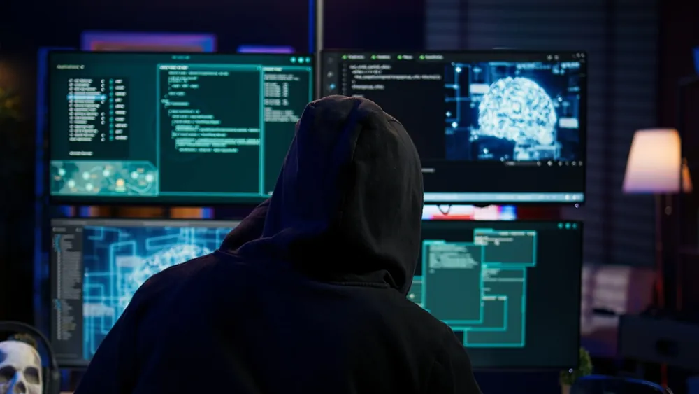 person hacker with four monitors