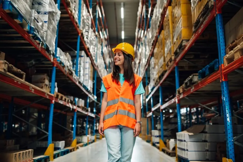 Distribution Centers vs Warehouses female worker walking through aisle searching for order