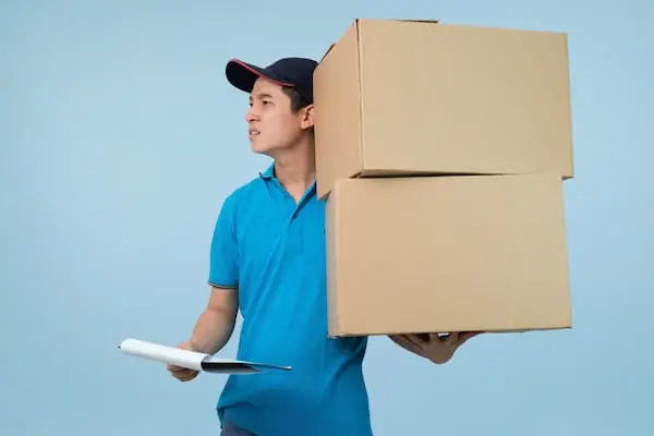 Seasonal Hiring Models parcel delivery man looking for delivery address on his clipboard