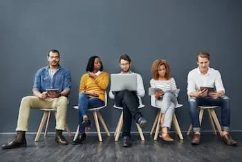seasonal-hiring-models-people-waiting-in-chairs-in-a-gray-room-to-be-interviewed-for-a-job-preview-version