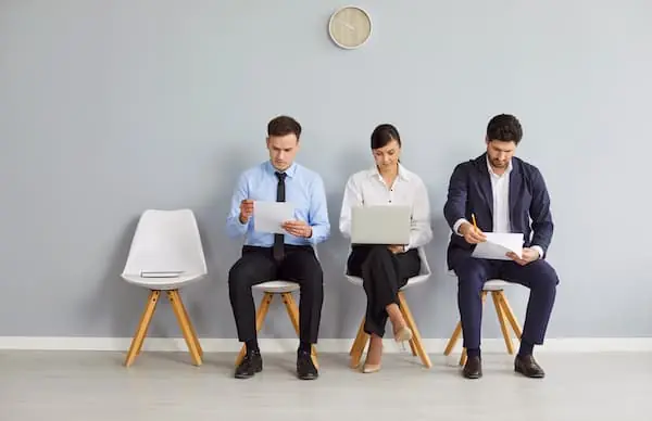 Seasonal Hiring Models three people waiting in a cream colored waiting room to be interviewed