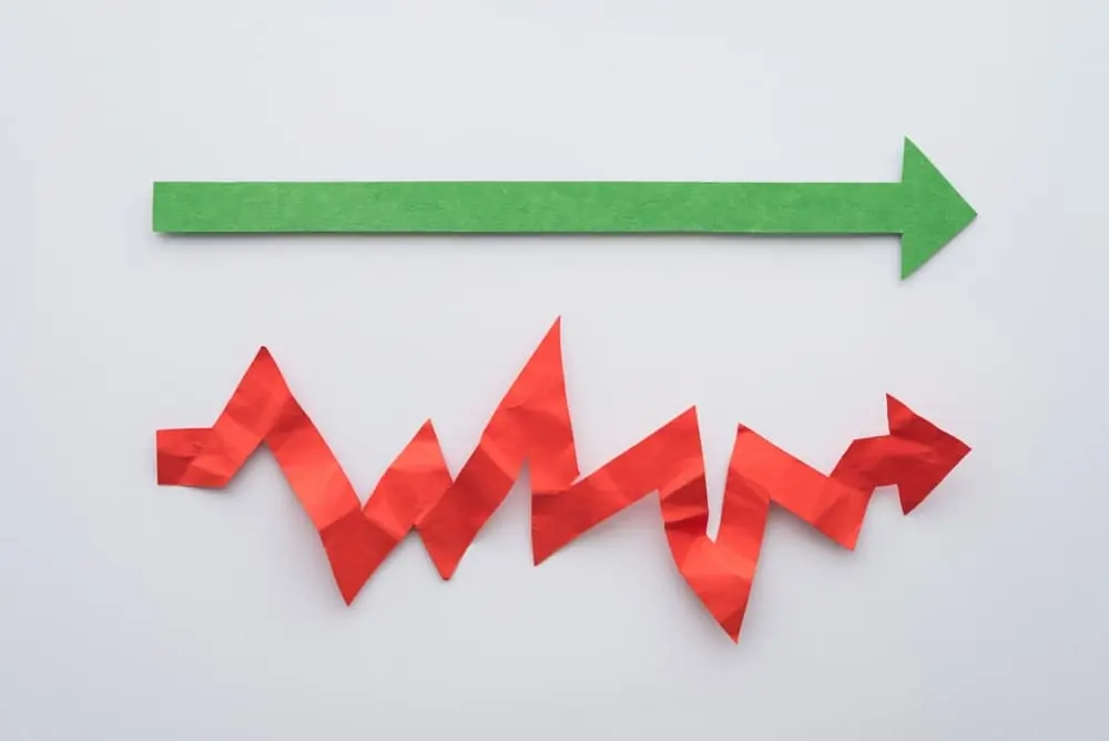 Try Before You Buy a green straight paper arrow and a red jagged paper arrow on top of a white desk