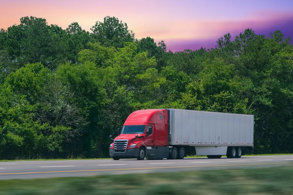 COMP semi-truck-driving-down-road-with-sunset