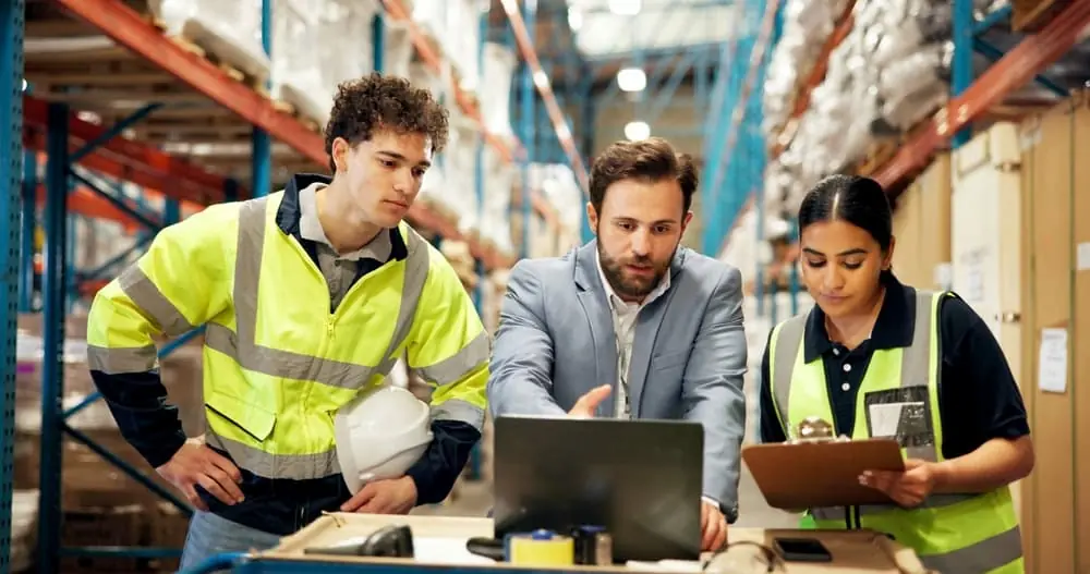 Harsh Reality of the Modern Freight Recession warehouse manager going over data with two workers in warehouse
