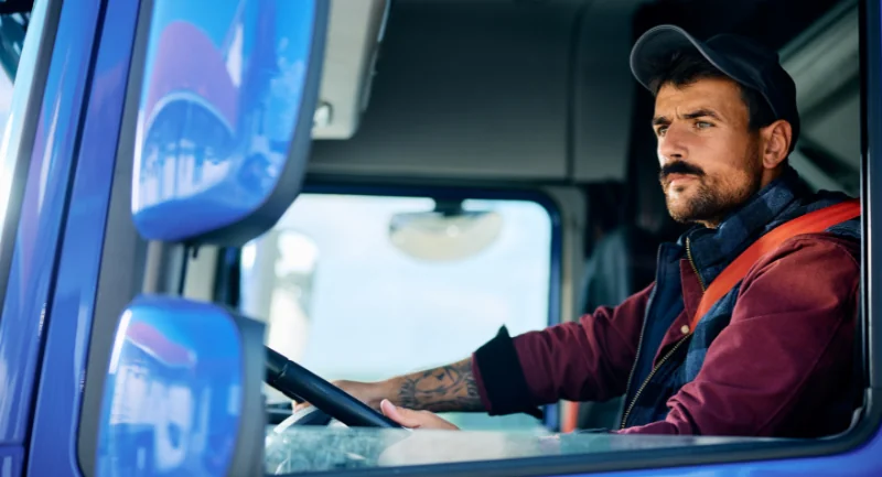 truck driver in front seat looking out his window
