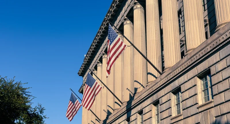 government building with US flat poles