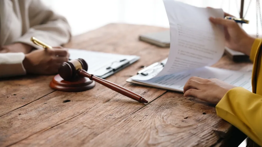 Yellow Corp Bankruptcy judge shifting through bankruptcy forms in front of an applicant next to a judge's gavel