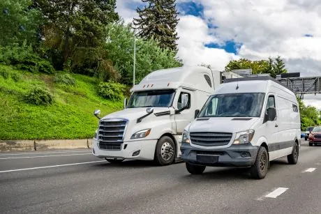 cargo van next to semi truck driving on highway
