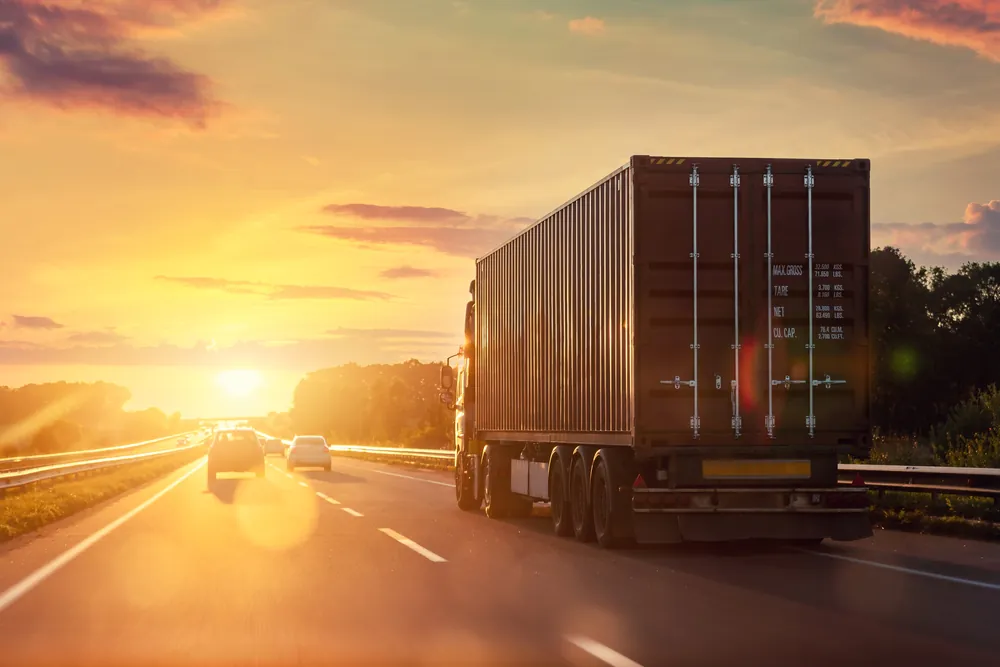truck driving towards the sunset