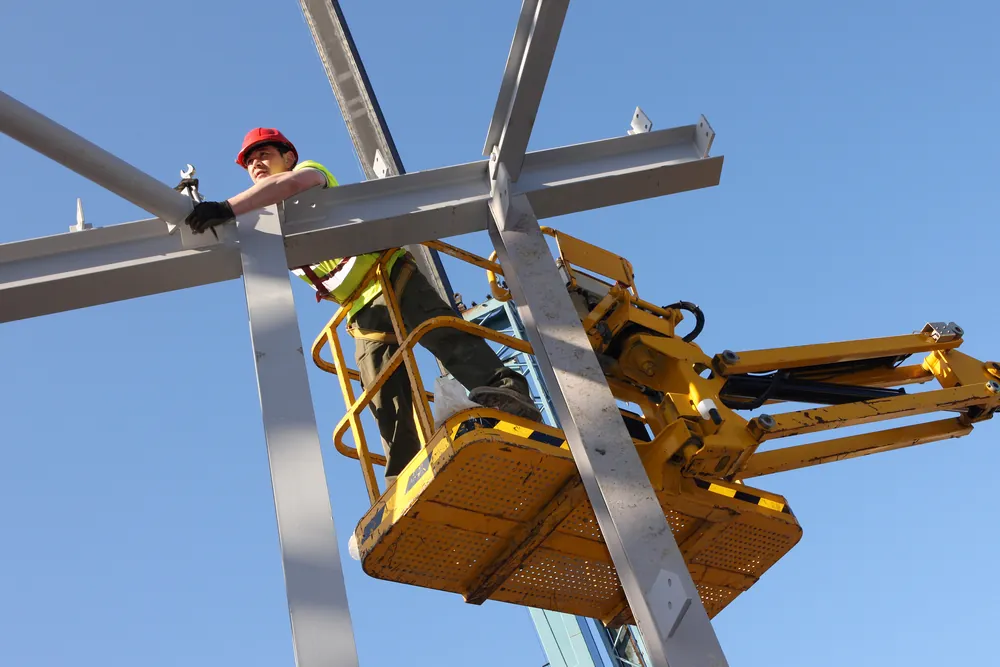 worker in cherry picker working on steel beams