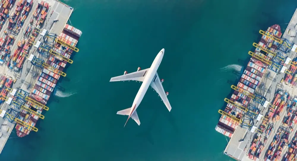 Freight Equipment Squeeze aerial view of cargo airplane flying over port channel