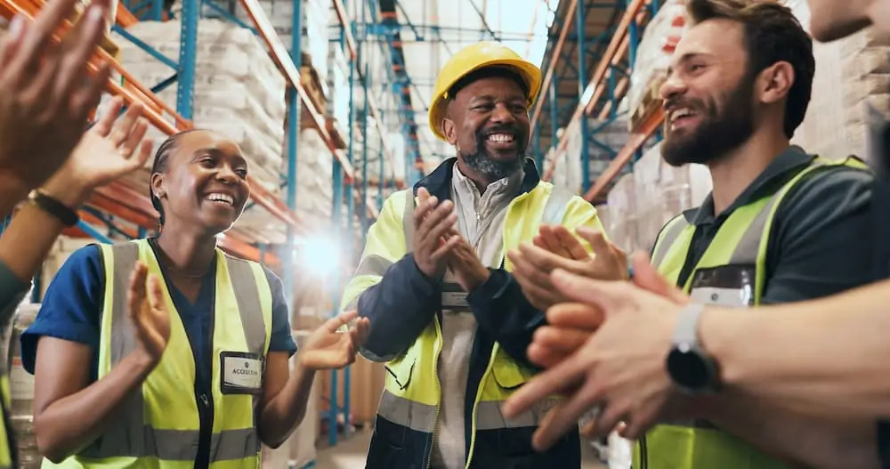Logistics Talent Shortage warehouse workers clapping happily during team meeting