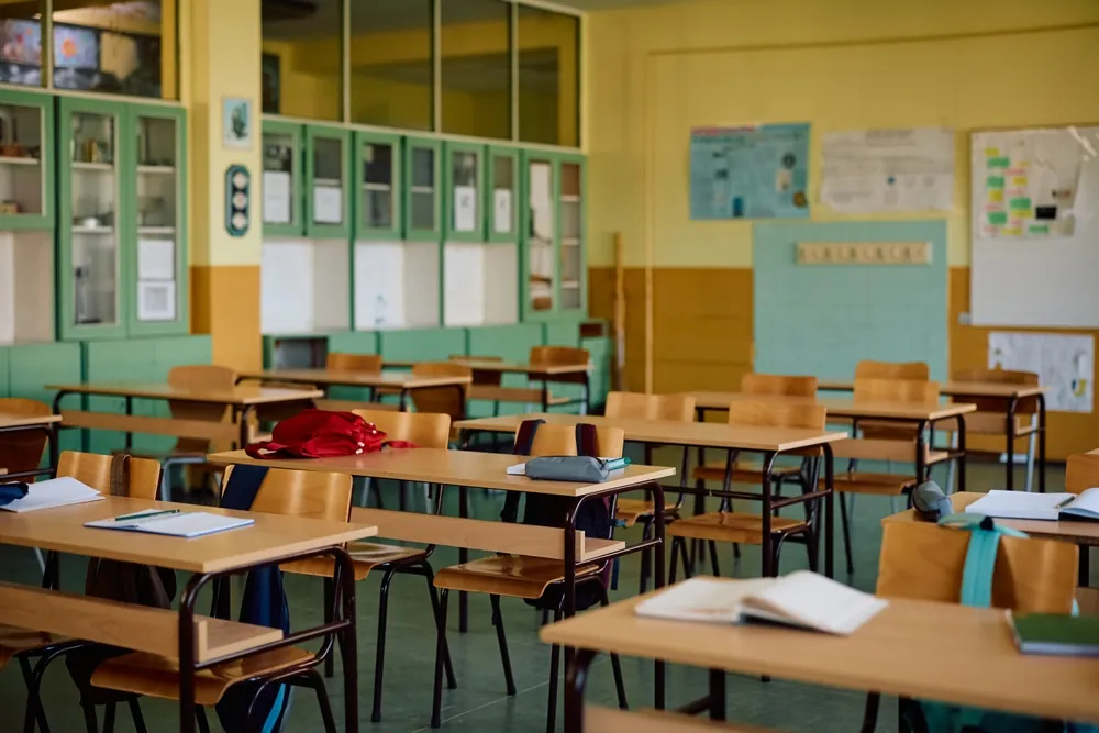 empty classroom with supplies on desks