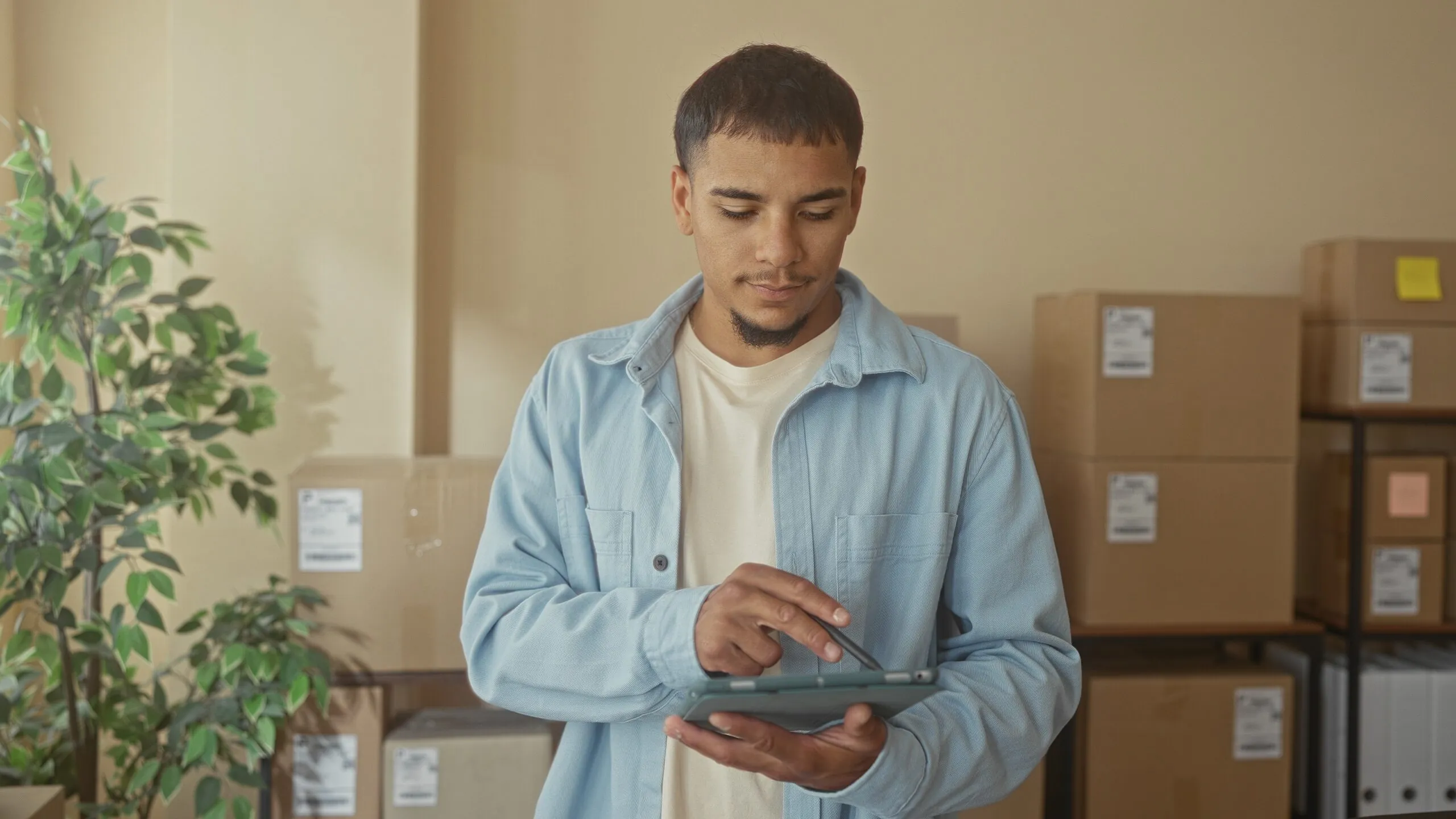 man on tablet with parcels behind