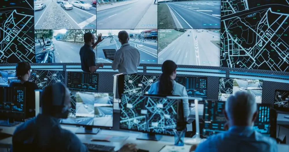 Truck Bottlenecks international logistics carrier analyzing real-time traffic footage on multiple screens