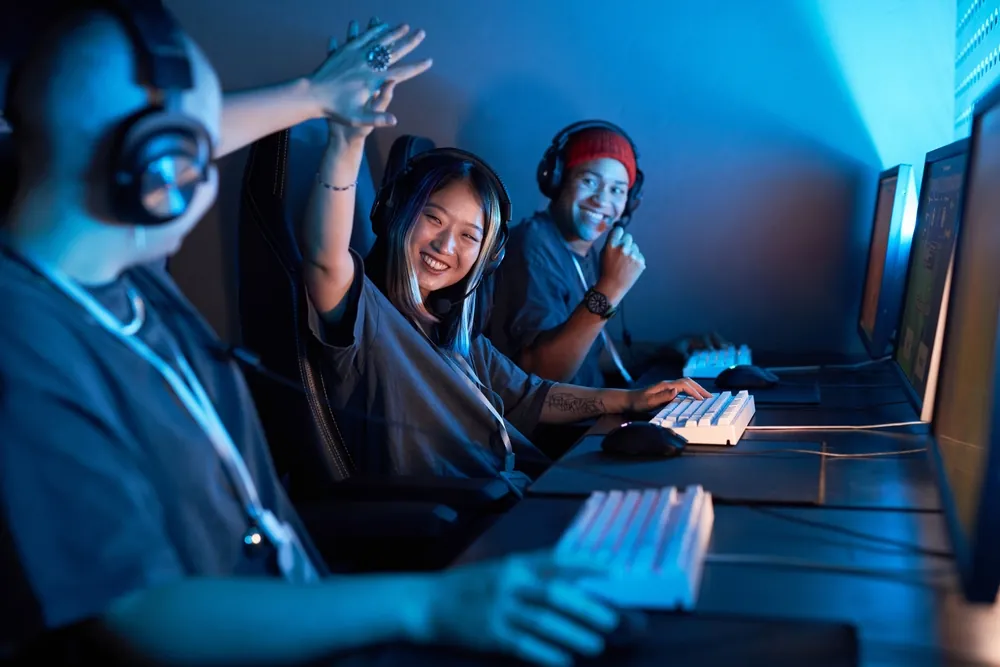 three people play video games on pc